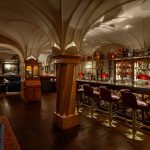 Die Bar im Schloss Fuschl ist rustikal mit dunkelbraunem Mobiliar und Fußböden aus edlem Holz ausgestattet. Die Bar sieht sehr edel aus - mit viel Glas und Verzierungen. Der Raum ist von schönen Säulen und Rundbögen geprägt.